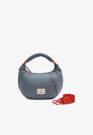 Weiche, himmelblaue Handtasche in Halbmondform mit gepolstertem Griff und abnehmbarem, leuchtend rotem Schulterriemen, vorne mit kleinem weißen Markenaufnäher.