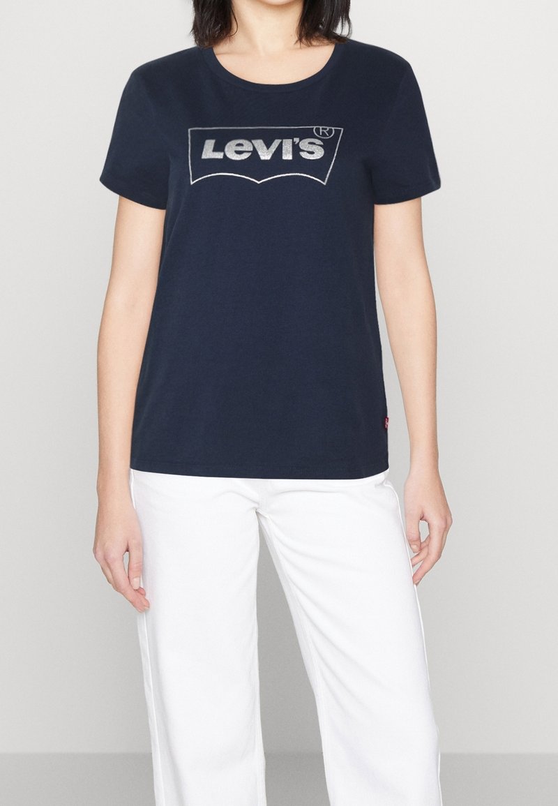 Námořnická modrá bavlněná tričko s kulatým výstřihem, se velkým stříbrným logem Levi's na přední straně a krátkými rukávy.