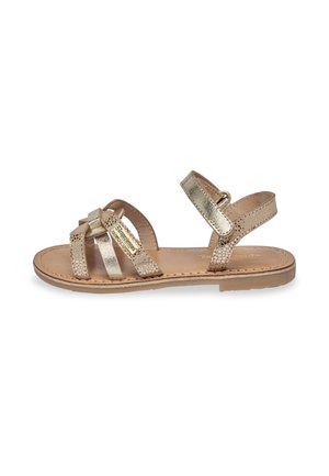 Sandales métalliques dorées avec des sangles tressées, semelle plate, sangle de cheville ajustable et accents texturés pour un meilleur grip et un confort accru.
