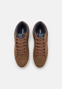 Bruine leren sneakers met donkerblauwe textielen voering, ronde neus, vetersluiting en witte rubberen zool. Merklogo op de tong.