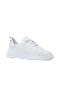 Weiße Sportschuhe mit einem strukturierten Mesh-Obermaterial, runder Zehenform, Schnürdesign und einer gepolsterten Sohle mit einem leichten Absatz.