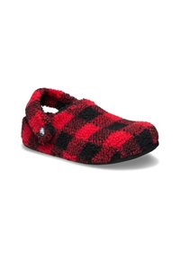 Chausson en laine à carreaux rouges et noirs avec une texture douce, un talon ouvert et une semelle en caoutchouc noir. Présente un logo rond sur le côté.