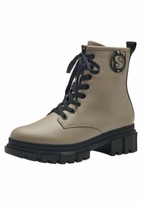 Bottines en cuir beige avec lacets noirs, semelle épaisse noire et accent de logo circulaire. Présente un bout rond et un col rembourré pour le confort.