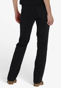 Zwarte denim jeans met een rechte pijp, voorzien van twee achterzakken en minimale stikseldetails. De textuur lijkt glad en licht rekbaar.