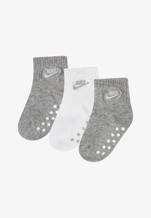 Trois paires de socquettes : une blanche et deux grises. Toutes arborent un logo, une texture côtelée et des points en caoutchouc sur la semelle pour une meilleure adhérence.