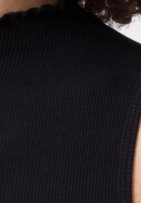 Czarna, prążkowana tkanina z wysokim dekoltem. Tekstura jest gładka z widocznymi pionowymi paskami. Krawędzie mają subtelny, postrzępiony detal.