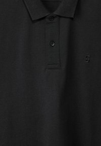 Black polo shirt made of textured fabric. Features a classic collar, three buttons, and a small embroidered logo.