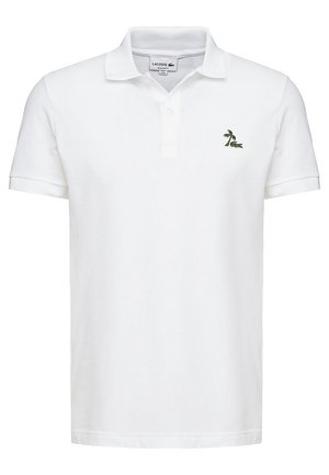 Polo blanc à manches courtes avec col et deux boutons, avec un petit logo vert de palmier et de crocodile sur la poitrine gauche.