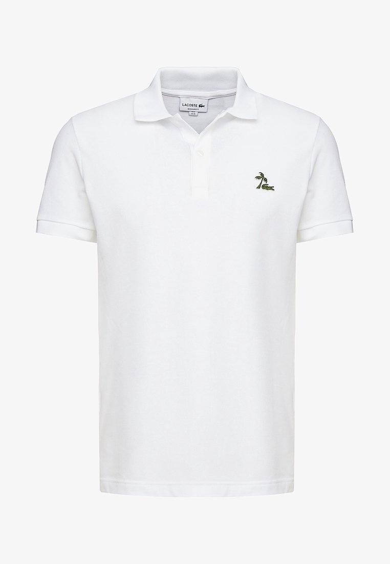 Polo blanc à manches courtes avec col et deux boutons, avec un petit logo vert de palmier et de crocodile sur la poitrine gauche.