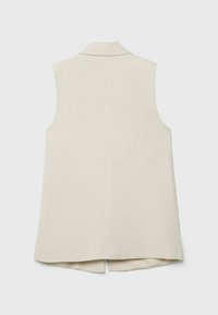 Chaleco sin mangas beige con cuello de muesca, diseño a medida, textura suave y una abertura en la parte trasera para mayor comodidad al moverse.