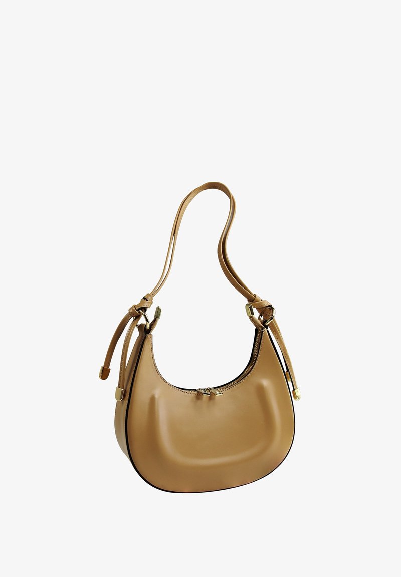 Sac à main en cuir tan avec une forme incurvée, texture lisse, fine bandoulière et accents en métal doré. Fermeture à glissière sur le dessus.