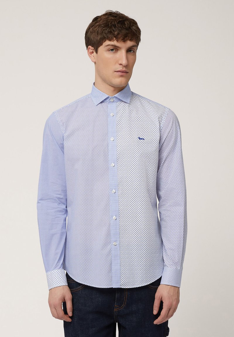 Heren button-up shirt in lichtblauw, met een gesplitst ontwerp met polka dot- en ruitpatronen. Glad stof met een standaard kraag en manchetten.