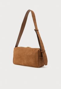 Καφέ τσάντα χειρός από σουέντ με ορθογώνιο σχήμα, ρυθμιζόμενο ιμάντα ώμου, χρυσά εξαρτήματα και λείο υφή. Κλείνει με φερμουάρ στο πάνω μέρος.
