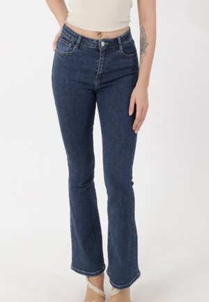 Dark blue flared jeans with a high waist, front and back pockets, and a faded texture. Features a metal button closure and stitching details.