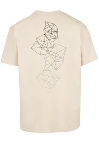 Beige cotton t-shirt featuring a geometric black line design on the back, with a relaxed fit and classic crew neckline.