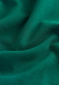 Tissu vert avec une texture lisse et un motif côtelé subtil, présentant une couleur profonde et riche ainsi qu'une apparence légère.