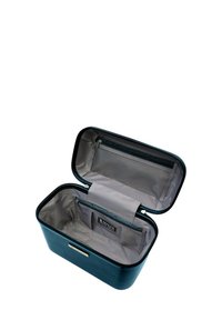 Porta trucco rettangolare di colore blu scuro, in materiale lucido. L'interno presenta una fodera grigia chiara con una tasca con zip e un compartimento di stoccaggio.