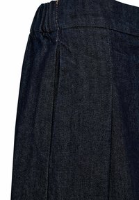 Tamna traper tkanina s pletenim dizajnom i naboranim pojasom. Tekstura je glatka s suptilnim tvil uzorkom i kontrastnim šavovima.