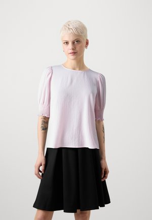 Heled roosa tekstuuriga topp lühikeste puffvarrukatega, millele on lisatud must flared seelik. Omab ümmargust kaelust ja soonitud detaile.