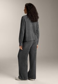 Sivý, textúrovaný úpletový lounge set s uvoľneným strihom a voľnými nohavicami, doplnený svetlosivými platformovými topánkami.