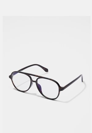 Lunettes aviator en écaille noire avec des verres transparents reposant sur une surface blanche.