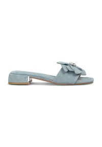 Lichtblauwe suède instapsandalen met een platte hak, met een opvallende bloemdetail en een decoratieve metalen accent aan de zijkant.