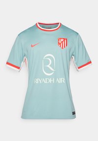 Camiseta deportiva azul claro con acentos rojos, presenta un cuello redondo, mangas cortas y un logotipo. Muestra "RIYADH AIR" de forma prominente.