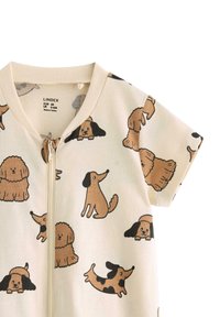 Short-sleeved onesie in cream cotton with a zipper, featuring a pattern of cartoon dogs in brown and black, against a light background.