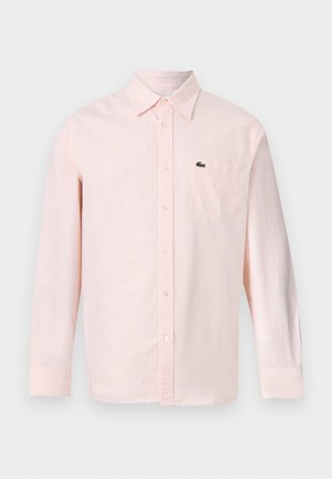 Šviesiai rožinė ir balta dryžuota ilgomis rankovėmis marškiniai su kišenėle krūtinės srityje ir mažu žaliu krokodilo logotipu kairėje pusėje.