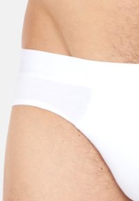 Witte katoenen slip met een gladde elastische tailleband en een getailleerde pasvorm, met minimale stiksels en een zachte textuur.