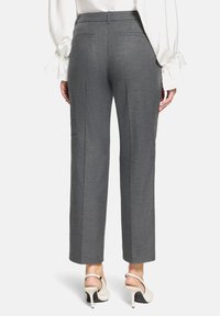 Grijze op maat gemaakte broek met een rechte pijp, voorzien van twee achterzakken en een gladde textuur. Gedeeltelijk met hoge hakken.
