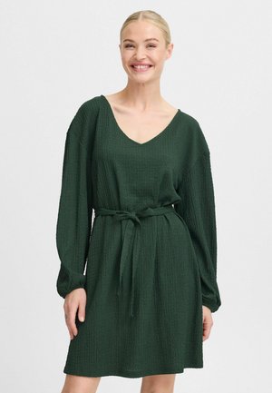 Dunkelgrünes Kleid aus strukturiertem Stoff, mit langen Ärmeln, V-Ausschnitt und gebundenem Taillengürtel. Kurze Länge mit lockerem Sitz.