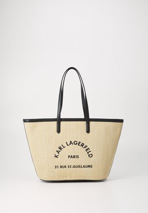 Beige vævet taske med sorte håndtag og kanter, med sort tekst "Karl Lagerfeld Paris 21 Rue St-Guillaume" på forsiden.