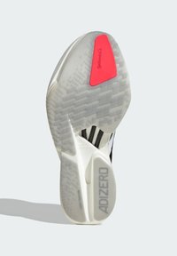Adizero jooksujalatsite välistald valge ja musta värviga, millel on tekstureeritud muster ja punane kummist aktsent koos "Continental" brändiga.
