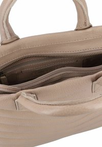 Beige leren handtas met gestikte geribbelde textuur, dubbele handvatten en ritscompartimenten. Het interieur heeft kaartslots en een extra ritsvak.