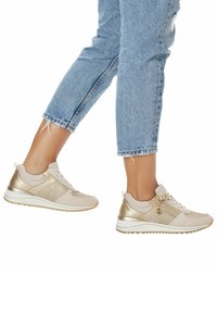Beige- und goldfarbene Sneakers mit Mesh- und glatten Texturen, ausgestattet mit Schnürverschluss, metallischen Akzenten und einer gepolsterten weißen Sohle.