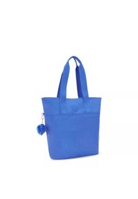 Borsa a spalla di stoffa blu con due robuste tracolle, un dettaglio a bottone sul davanti e un charm pom-pom blu soffice attaccato sul lato.