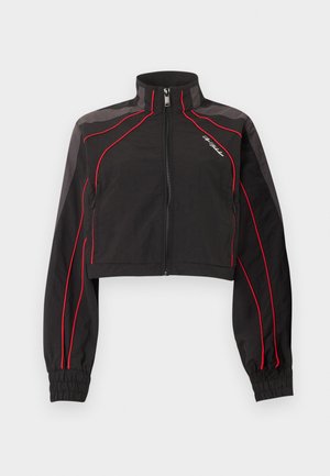 Schwarze, kurz geschnittene Jacke mit roter Paspelierung, hohem Kragen, Frontreißverschluss, elastischen Bündchen und kleinem weißen Schriftlogo auf der linken Brust.