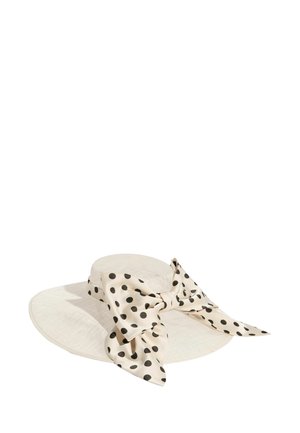 Sombrero de paja blanco de ala ancha con un gran lazo crema con lunares negros atado alrededor de la copa.