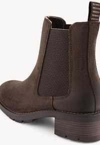 Stivale alla caviglia in suede marrone con pannelli laterali elastici texturizzati, punta arrotondata e tacco impilato. Presenta dettagli di cucitura e una suola durevole.