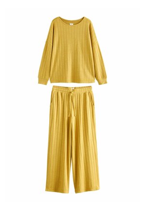 Žltý rebrovaný loungewear set so sveterom s dlhým rukávom a okrúhlym výstrihom, a voľne strihanými nohavicami s pružným pásom a bočnými vreckami.