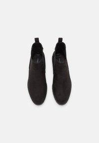 Stivaletti neri in suede con finitura liscia, pannelli laterali elasticizzati e linguette per una facile calzata; design con punta rotonda e suola piatta.