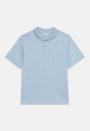 Lichtblauw poloshirt met korte mouwen, drie knopen en een zachte kraag, plat neergelegd op een effen witte achtergrond.