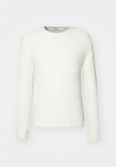Pull en tricot blanc avec un col rond, des manches longues et des poignets côtelés. La texture semble douce et légèrement pelucheuse.