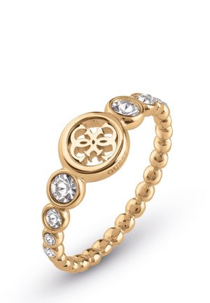 Bague perlée ton or avec des cristaux ronds transparents et une découpe circulaire centrale présentant un motif floral.