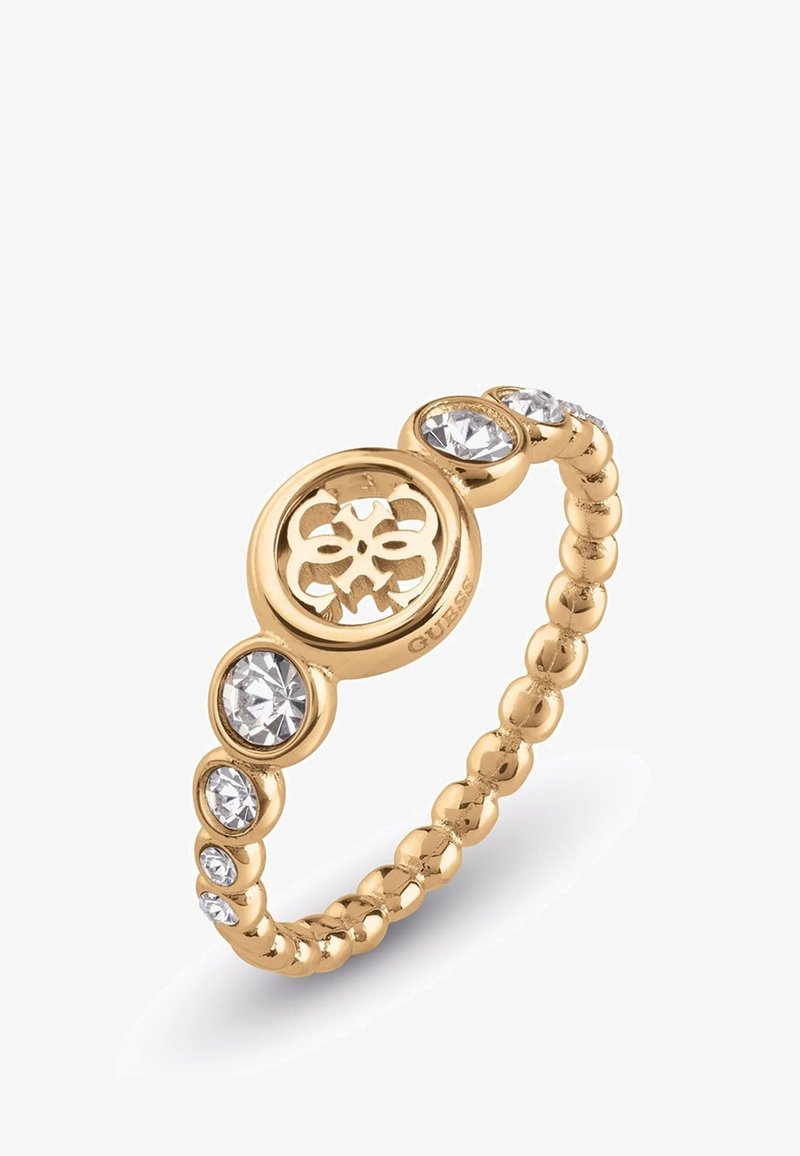 Bague perlée ton or avec des cristaux ronds transparents et une découpe circulaire centrale présentant un motif floral.