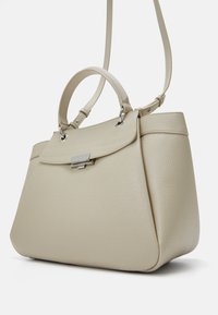 Borsa a mano in pelle beige con texture a ciottolo, dalla forma strutturata, con doppio manico e tracolla removibile. Presenta hardware argentato e chiusura a patta.