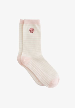 Chaussettes rayées en beige doux et rose pâle, avec une broderie rouge en forme de coquillage sur la cheville extérieure. Texture douce avec bord-côte.