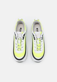 Sneakers a rete giallo neon e bianco con dettagli neri, suola spessa e lacci riflettenti, dotati di collare imbottito per il comfort.