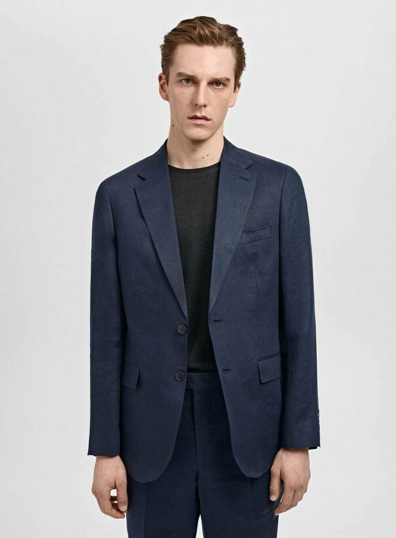 Veste de costume bleu marine en tissu texturé, dotée de deux boutons à l'avant, d'une poche poitrine simple et de revers droits.
